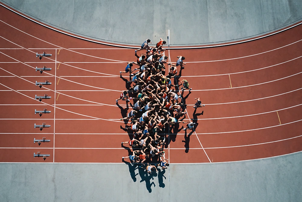 A large crowd of runners competing on a track, metaphorically representing healthcare's rushed adoption of ambient AI scribes and ambient documentation.