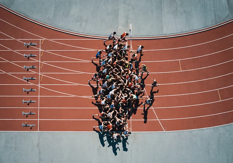 A large crowd of runners competing on a track, metaphorically representing healthcare's rushed adoption of ambient AI scribes and ambient documentation.